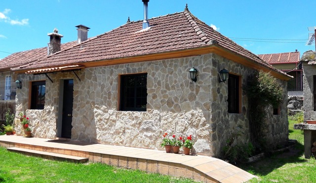 A FULL-SIZED house with a fenced-in property, a garden, and a barbecue.